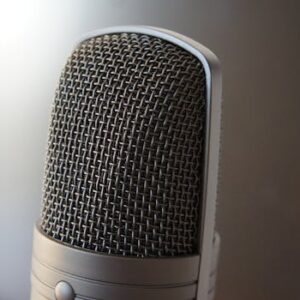 Detailed view of a professional condenser microphone with a blurred backdrop, ideal for audio equipment themes.