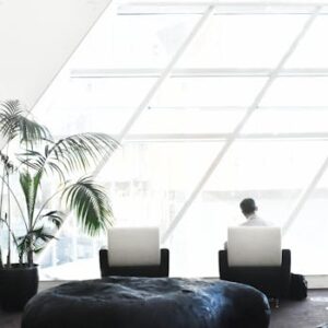 Spacious modern lounge with minimalist decor, featuring large windows and stylish seating.